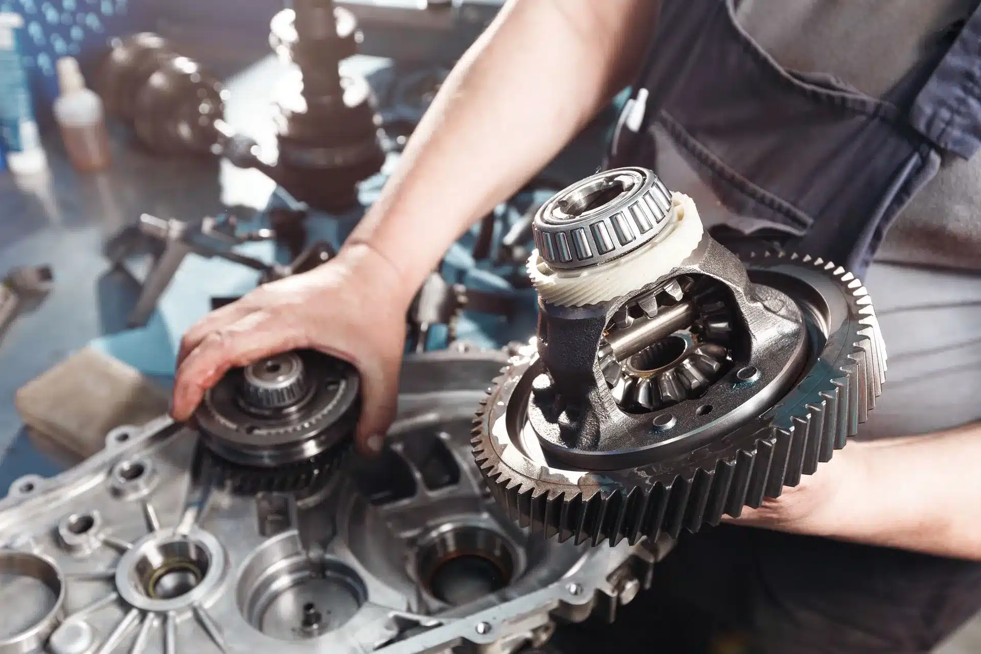 Close-up of a mechanic inspecting transmission components of a vehicle at Schindler's Garage.