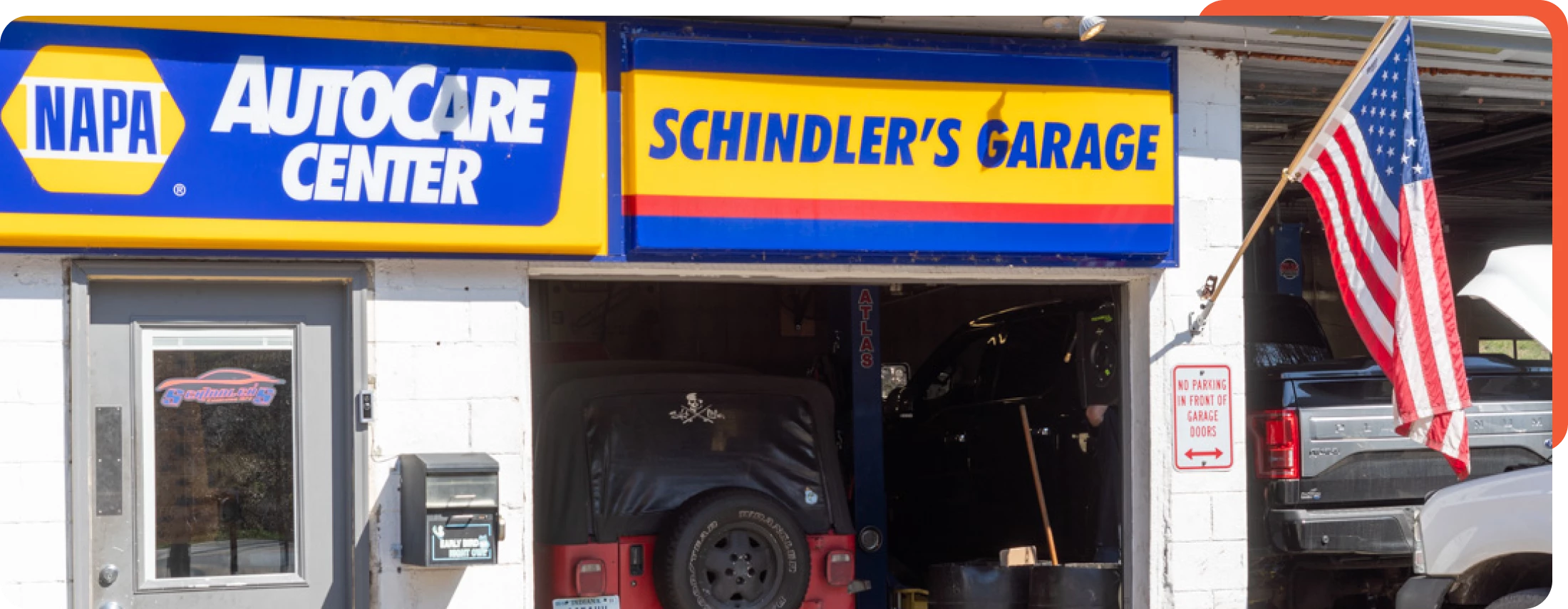 View of the garage bays from outside, showing open service doors at Schindler's Garage.