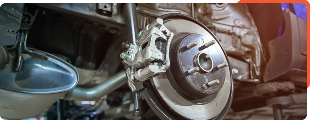 Close-up view of a car braking system, including brake pads, calipers, and rotors, inspected during maintenance at Schindler's Garage.