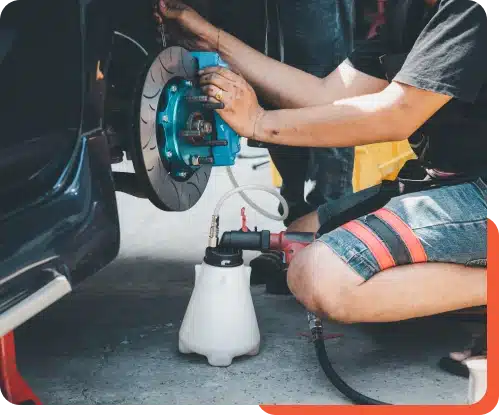 Close-up view of a car braking system, including brake discs, pads, and calipers, inspected during maintenance at Schindler's Garage.