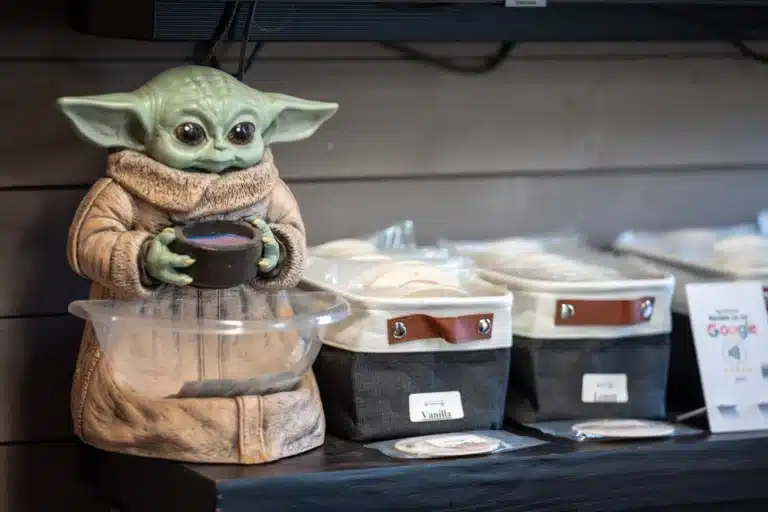 Baby Yoda figurine displayed in the reception area of Schindler's Garage, adding a playful touch to the environment beside the a selection of drinks, refreshments, and snacks for customers.