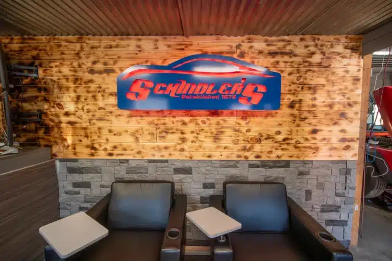 Logo of Schindler's Garage displayed prominently in the lobby, with comfortable seating arranged nearby for customers.