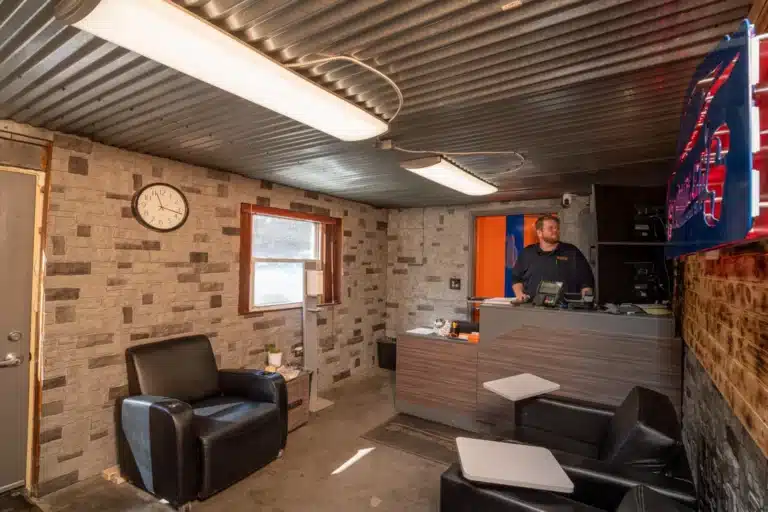 Panoramic view of the reception area at Schindler's Garage, showcasing a spacious and inviting environment with comfortable seating, a well-organized reception desk, and visible signage.