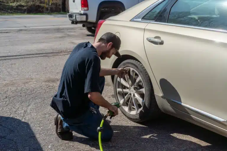 Mechanic inspecting tire tread and pressure at Schindler's Garage.