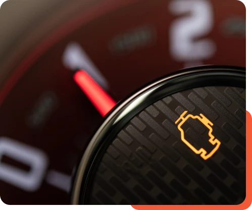 Dashboard of a vehicle at Schindler's Garage displaying the illuminated check engine light, indicating a potential issue with the vehicle's engine or emissions system.