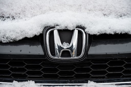 Honda winter maintenance tips in Flyods. Knobs, IN with Schindler's Garage. Image of honda car ornament on grill of car with snow on it.