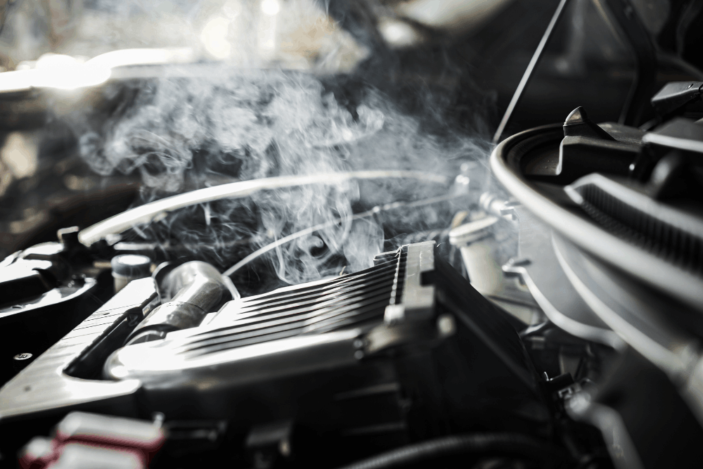 Engine overheating, auto repair in Floyds Knobs, IN, at Schindler's Garage. Image of steam rising from an overheated engine bay, highlighting the need for prompt cooling system diagnostics and repair to protect engine performance and prevent costly damage.