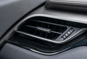 a/c repair, auto repair in Floyds Knobs, IN at Schindler's Garage. Close-up of a car’s dashboard air conditioning vent, highlighting airflow direction controls and vent detail. Ideal for illustrating cabin comfort or vehicle HVAC performance.