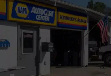 Front of Schindler's Garage showing their signage, entrance and outside lot.