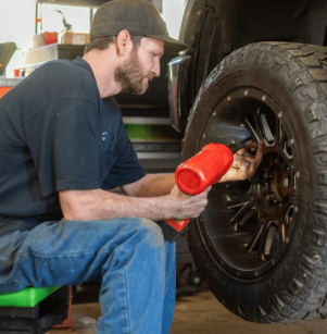 Tire Maintenance at Schindler's Garage in Floyds Knobs, IN. Image showing a mechanic adjusting a tire on a vehicle, demonstrating Schindler's Garage's expertise in providing detailed and thorough tire care services.