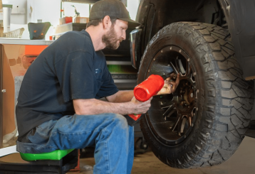 Tire Maintenance at Schindler's Garage in Floyds Knobs, IN. Image showing a mechanic adjusting a tire on a vehicle, demonstrating Schindler's Garage's expertise in providing detailed and thorough tire care services.